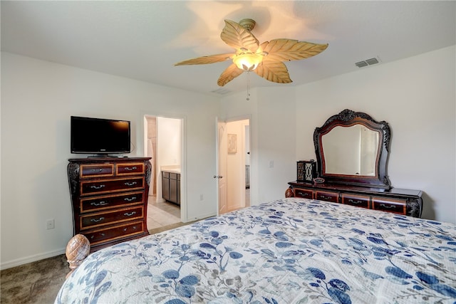 carpeted bedroom with ceiling fan and ensuite bath