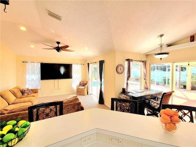 kitchen with vaulted ceiling, a textured ceiling, hanging light fixtures, light carpet, and white cabinets