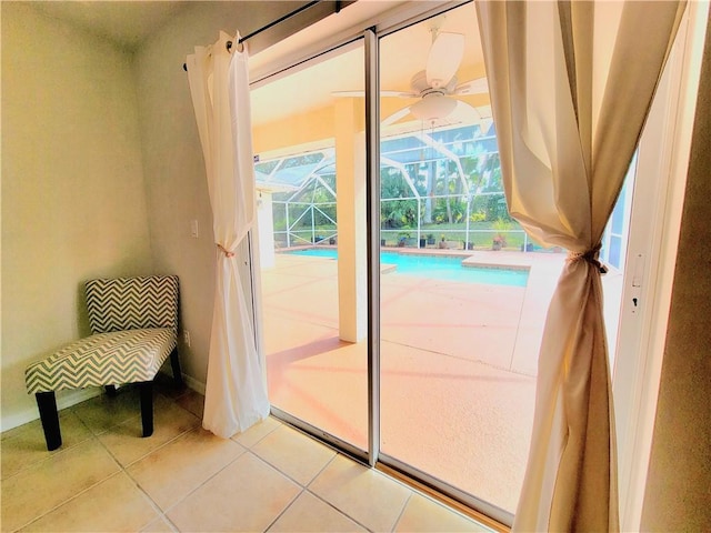 doorway with light tile patterned floors and ceiling fan