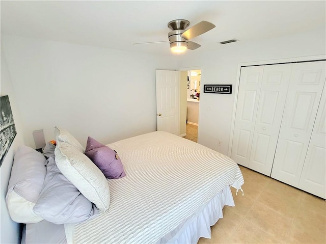 bedroom featuring ceiling fan, a closet, and light tile patterned floors