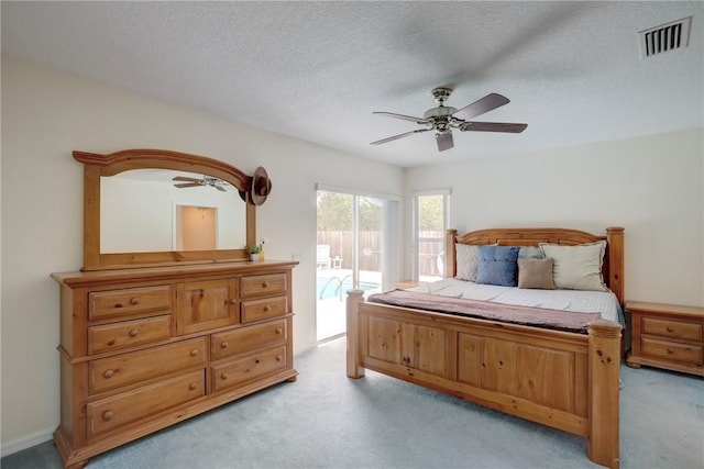 bedroom featuring light carpet, ceiling fan, access to outside, and a textured ceiling