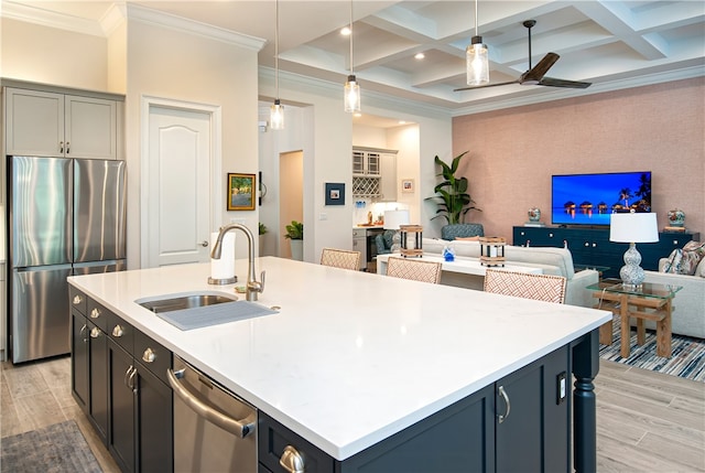 kitchen with sink, a kitchen island with sink, appliances with stainless steel finishes, and coffered ceiling