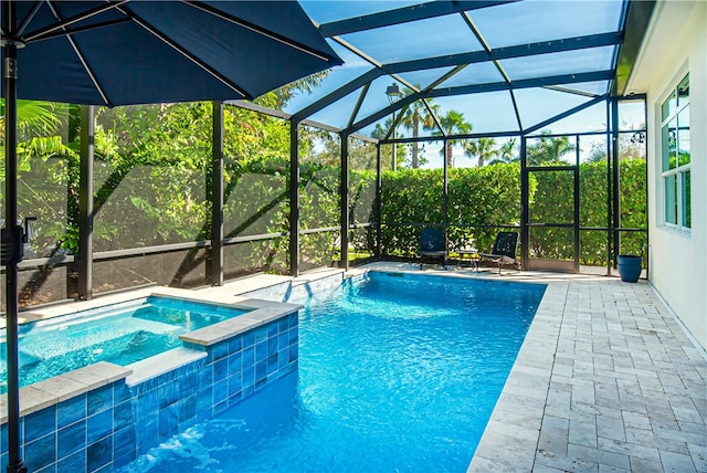 view of pool with a patio area, a lanai, and an in ground hot tub