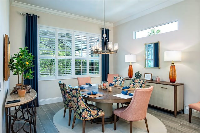 dining space featuring ornamental molding, wood-type flooring, and a notable chandelier