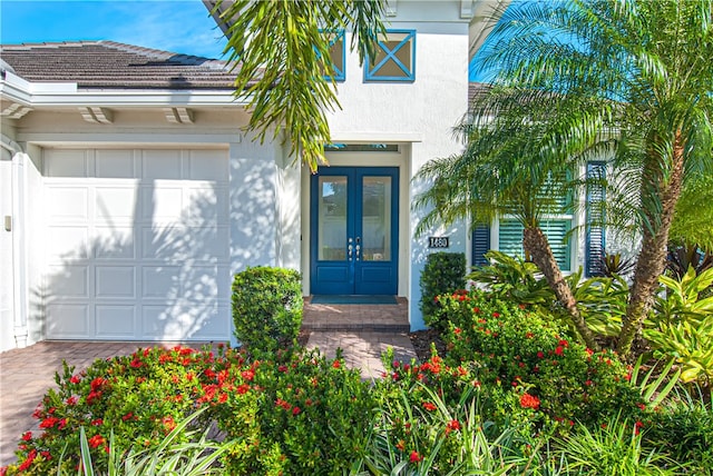 property entrance featuring a garage and french doors