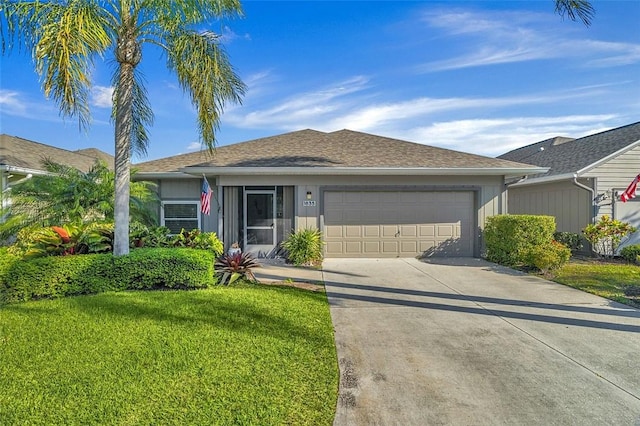 ranch-style house with a front lawn, roof with shingles, concrete driveway, and an attached garage