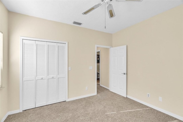 unfurnished bedroom featuring carpet, visible vents, a closet, and baseboards