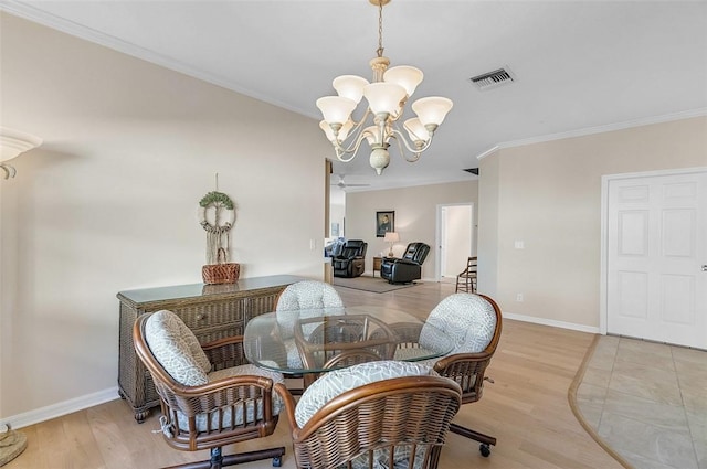 dining room with visible vents, baseboards, light wood-style floors, and crown molding