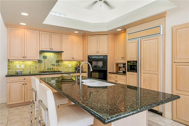 kitchen with dobule oven black, stainless steel gas cooktop, a sink, and light brown cabinetry