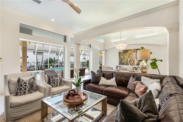 living room with decorative columns, ornamental molding, arched walkways, and ceiling fan with notable chandelier