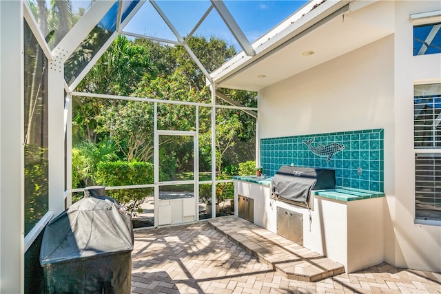 view of patio featuring area for grilling and glass enclosure