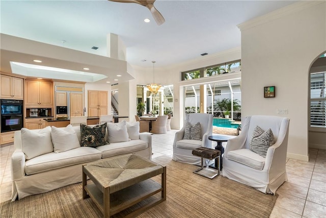 living area featuring light tile patterned floors, crown molding, arched walkways, and recessed lighting