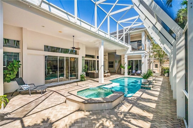 view of pool featuring a lanai, a patio area, a pool with connected hot tub, and a ceiling fan