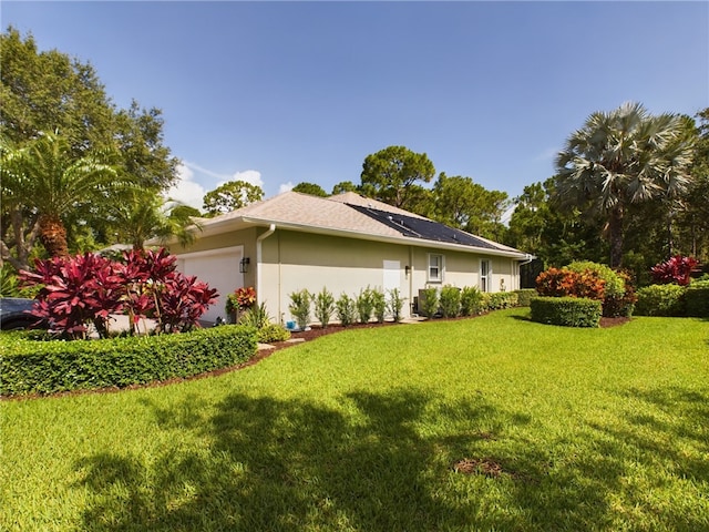 view of home's exterior with a garage and a lawn