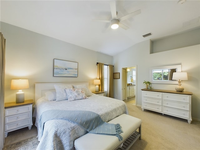 bedroom with ensuite bath, ceiling fan, light colored carpet, and lofted ceiling