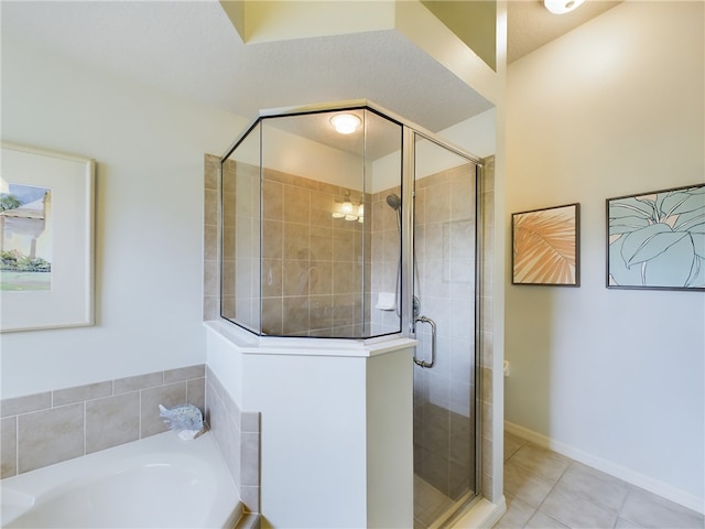 bathroom with tile patterned floors, shower with separate bathtub, and a textured ceiling