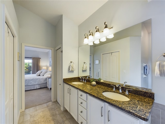 bathroom featuring tile patterned flooring, vanity, and vaulted ceiling