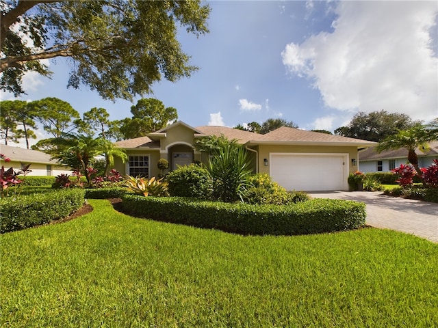 single story home featuring a garage and a front yard