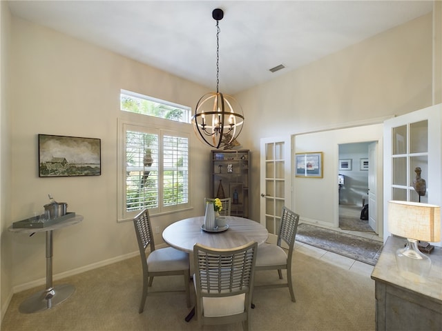 carpeted dining area featuring an inviting chandelier