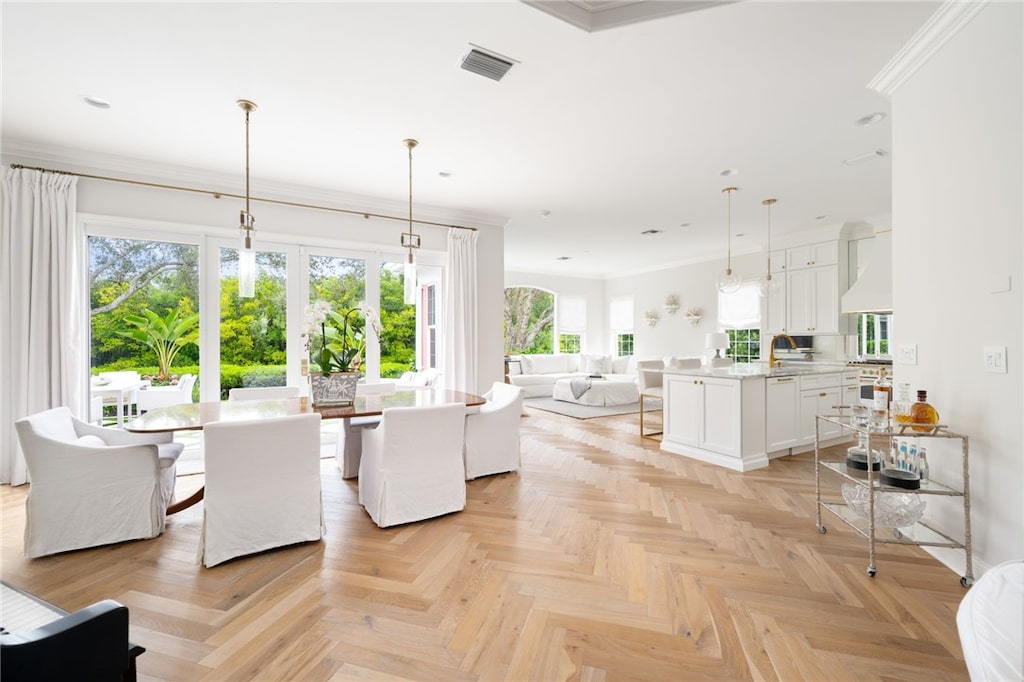 living room with light parquet flooring, ornamental molding, and sink