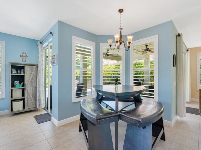 dining area with a wealth of natural light, light tile patterned floors, and baseboards