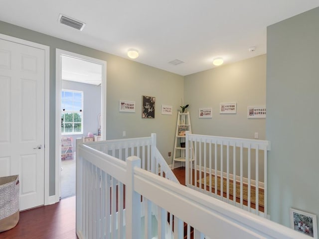 interior space featuring an upstairs landing, dark wood finished floors, and visible vents