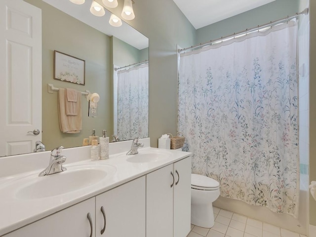 bathroom with tile patterned floors, shower / bath combination with curtain, a sink, and toilet