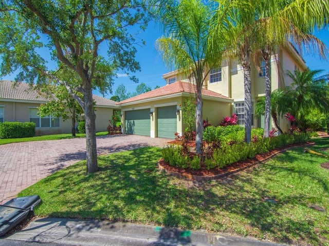 view of front of property with stucco siding, a tile roof, a front lawn, an attached garage, and driveway