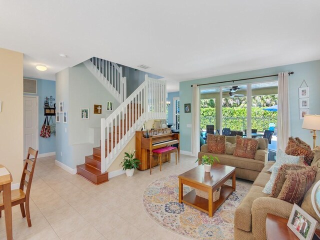 living room featuring visible vents, baseboards, ceiling fan, and stairs