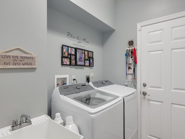 washroom featuring independent washer and dryer, laundry area, and a sink
