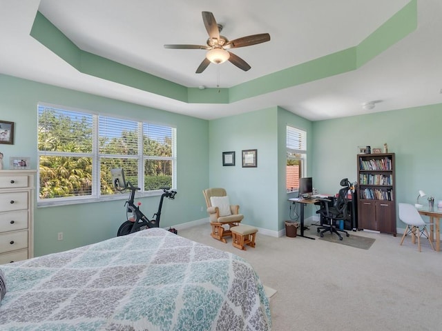 bedroom featuring carpet floors, baseboards, a raised ceiling, and ceiling fan