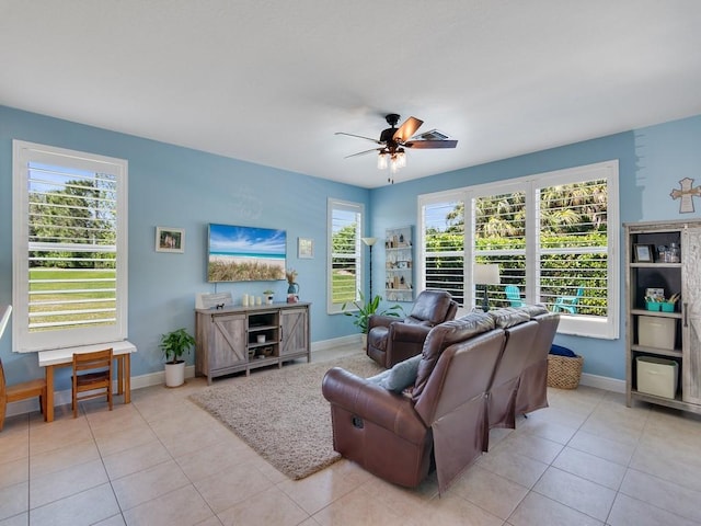 living area with tile patterned flooring, baseboards, and a ceiling fan
