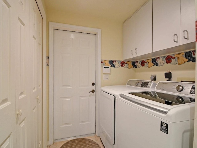 laundry area featuring cabinet space, light tile patterned floors, and washer and dryer