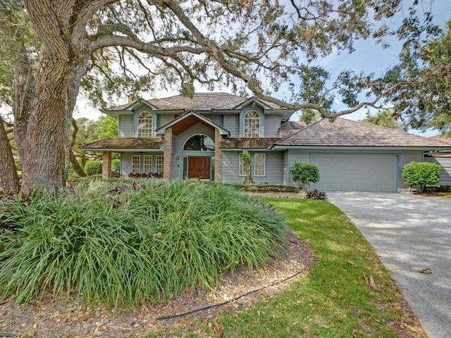 traditional-style home featuring a garage, concrete driveway, and a chimney