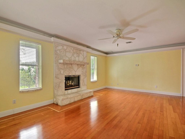 unfurnished living room with a large fireplace, visible vents, baseboards, light wood-style flooring, and ornamental molding