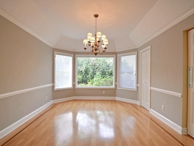 unfurnished room with lofted ceiling, a notable chandelier, baseboards, light wood-style floors, and ornamental molding