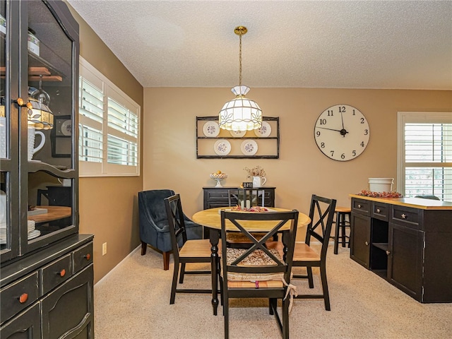 carpeted dining space with a textured ceiling