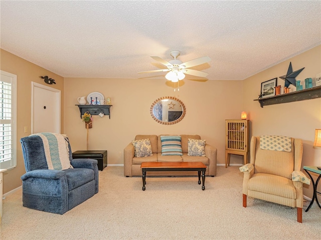 living area with a textured ceiling, carpet, a ceiling fan, and baseboards