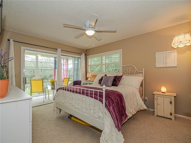 bedroom featuring a textured ceiling, ceiling fan, and light carpet