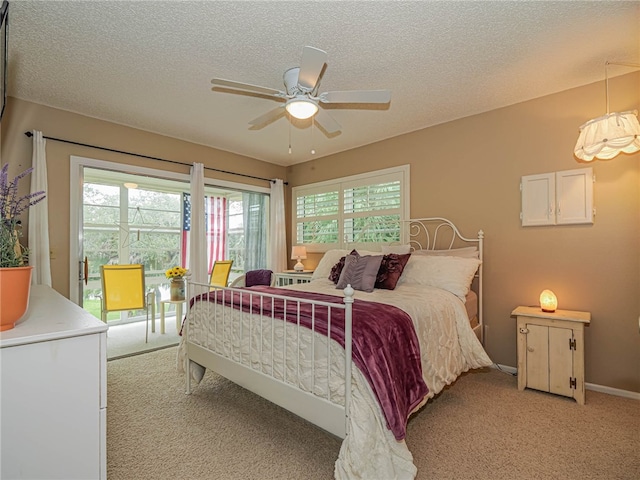 bedroom featuring a textured ceiling, ceiling fan, baseboards, and light colored carpet