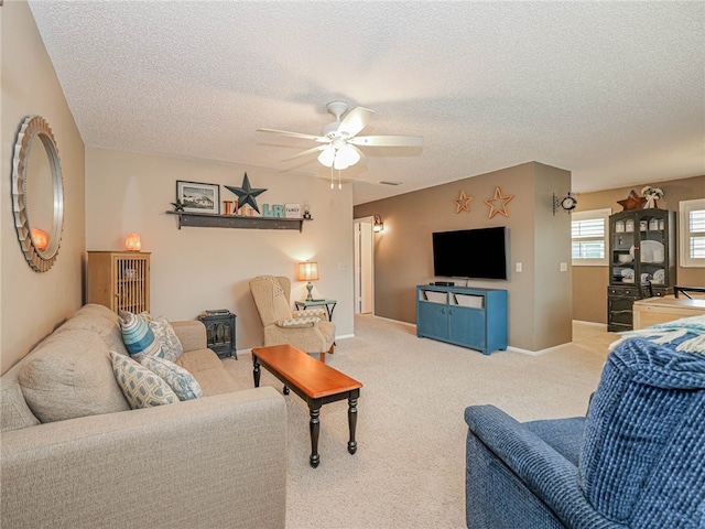 living room featuring carpet, a textured ceiling, and a ceiling fan