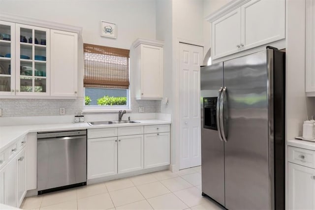2214 Falls Cir, Vero Beach, FL 32967 - kitchen with sink, light tile patterned floors, white cabinets, stainless steel appliances, and backsplash