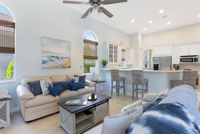 2214 Falls Cir, Vero Beach, FL 32967 - living room with light tile patterned floors, ceiling fan, and a high ceiling