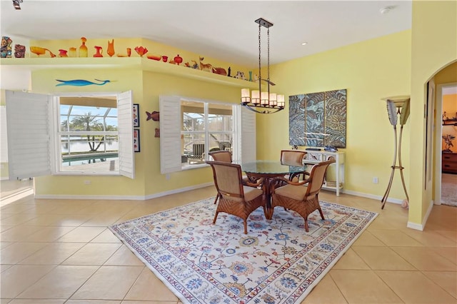 5688 Riverboat Cir SW, Vero Beach, FL 32968 - dining room with light tile patterned floors, arched walkways, baseboards, and a water view