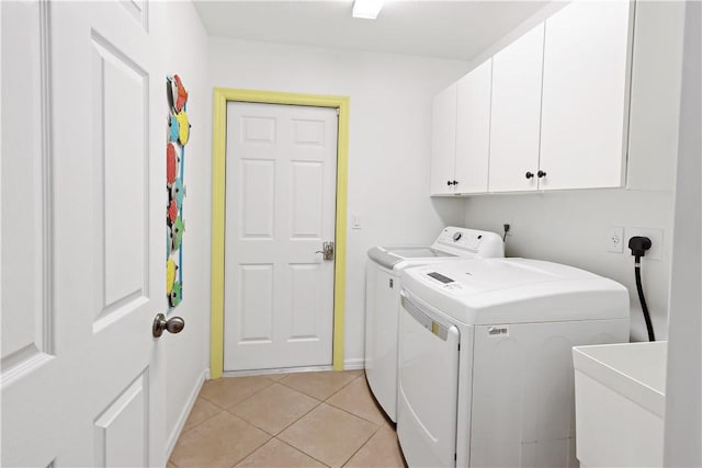 5688 Riverboat Cir SW, Vero Beach, FL 32968 - laundry area featuring washing machine and clothes dryer, cabinet space, baseboards, and light tile patterned floors
