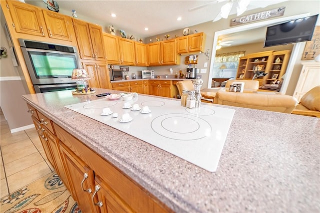 kitchen featuring white electric cooktop, oven, light tile patterned flooring, light countertops, and recessed lighting