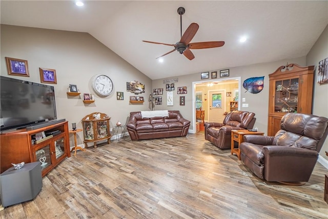 living area featuring lofted ceiling, ceiling fan, light wood-type flooring, and baseboards