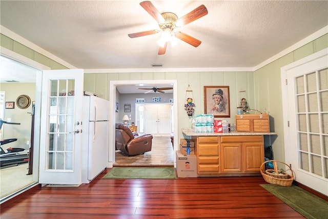 interior space with crown molding, a textured ceiling, visible vents, and dark wood-type flooring