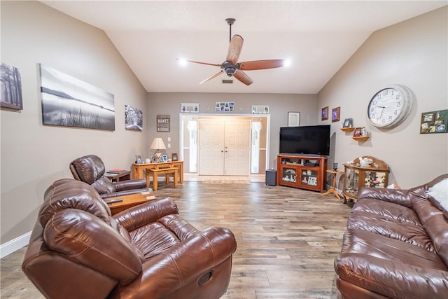 living area featuring vaulted ceiling, wood finished floors, a ceiling fan, and baseboards