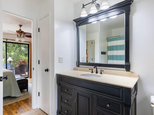 bathroom featuring ceiling fan, vanity, ensuite bath, and wood finished floors